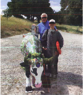 Bruce Brandenburg and his 'Little Brother' Shane Blume taking a picture with a painted cow sculpture